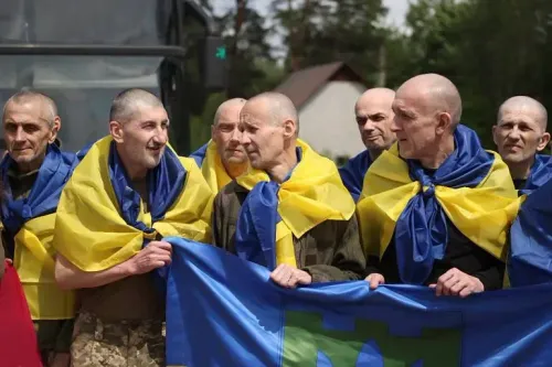 مجموعة من الجنود الأوكرانيين المحررين، يرتدون ملابس مموهة وأعلام أوكرانية، يعبرون عن الفرح بعد تبادل أسرى الحرب.