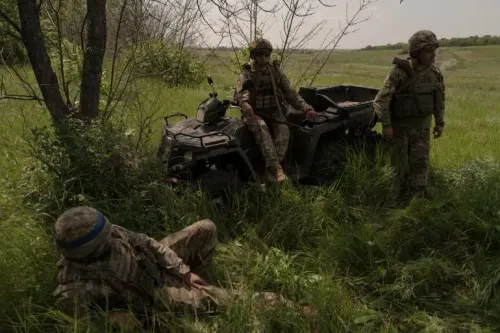 جنود أوكرانيون يستريحون بالقرب من مركبة رباعية الدفع في منطقة عشبية، وسط الأجواء المتوترة نتيجة الصراع المستمر.