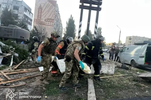 فرق الإنقاذ تحمل جثثًا من موقع قصف في أوكرانيا، مع وجود مبانٍ مدمرة في الخلفية، مما يعكس آثار الحرب المستمرة.