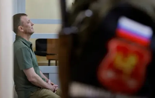 اللواء إيفان بوبوف يجلس في قاعة المحكمة، مع التركيز على تعبيره الجاد، بينما يظهر شعار القوات الروسية في الخلفية.