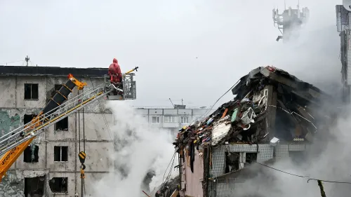 مشهد لمبنى سكني مدمر في بولتافا، أوكرانيا، مع وجود رجال إطفاء في سلة رفع وسط الدخان، بعد غارة روسية أسفرت عن مقتل 14 شخصًا.