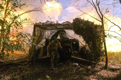 صورة لجندي أوكراني يتحرك من خلف ساتر في منطقة قتال مشتعلة، حيث تتصاعد النيران والدخان في الخلفية، مما يعكس تصاعد التوترات العسكرية في دونيتسك.