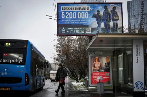 لافتة إعلانات في موسكو تعرض مكافآت مالية للتجنيد العسكري، مع صورة لجنود في الخلفية، بينما يظهر رجل ينتظر في محطة الحافلات.