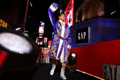 ريان غارسيا يرتدي رداءً مزينًا بألوان زاهية ويحيي الجمهور قبل نزال في ساحة تايمز سكوير، وسط أضواء الإعلانات الساطعة.