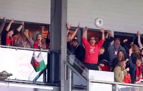 جماهير نادي ريكسهام تحتفل بفوز الفريق في مباراة حاسمة، مع تعبيرات الفرح والحماس في المدرجات.