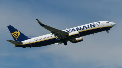 طائرة راين إير تحلق في السماء، تعكس سياسة الشركة الصارمة ضد السلوك المشاغب للركاب وتأثيره على الرحلات.