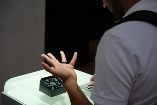 رجل يستعرض جهازًا صحيًا مبتكرًا على طاولة عرض، مع التركيز على يده التي ترتدي حلقة ذكية.