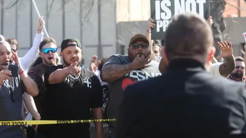 تجمع محتجون أمام مبنى ولاية كانساس، حيث يظهر بعضهم يحملون لافتات ويعبرون عن آرائهم ضد قداس أسود.