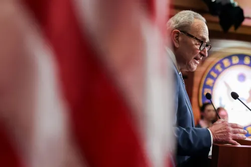 تشاك شومر، زعيم الأقلية في مجلس الشيوخ، يتحدث خلال مؤتمر صحفي في واشنطن، مع العلم الأمريكي خلفه، معبراً عن قلقه بشأن تمويل الرعاية الصحية.