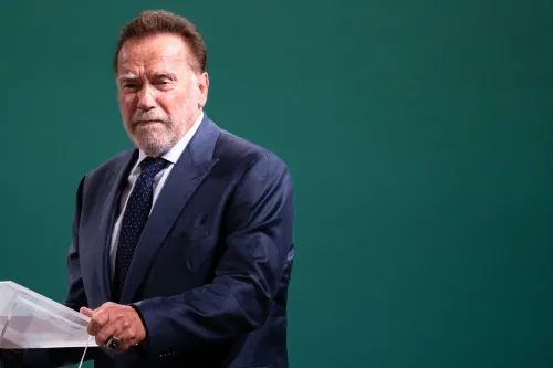 أرنولد شوارزنيغر يتحدث في مؤتمر صحفي، مع خلفية خضراء، معبرًا عن آرائه حول إعادة تقسيم الدوائر الانتخابية في الولايات المتحدة.