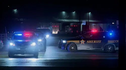 سيارات شرطة مضاءة بأضواء زرقاء وحمراء في موقع حادث إطلاق نار جماعي في نيو ألباني، حيث تم إجلاء الموظفين وتأمين المنطقة.