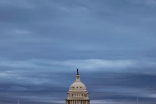 قبة مبنى الكابيتول الأمريكي تحت سماء ملبدة بالغيوم، تعكس أجواء التوتر السياسي حول التمويل وإعادة فتح الحكومة.