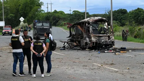 موقع انفجارات في كالي، كولومبيا، مع وجود عناصر من الشرطة والجيش قرب حافلة محترقة، تعكس تصاعد العنف المستهدف ضد قوات الأمن.