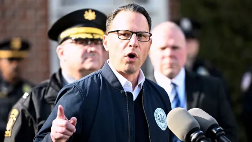 رجل يتحدث أمام الكاميرا خلال مؤتمر صحفي، مع وجود ضباط شرطة خلفه، في سياق حادثة حرق قصر حاكم بنسلفانيا.