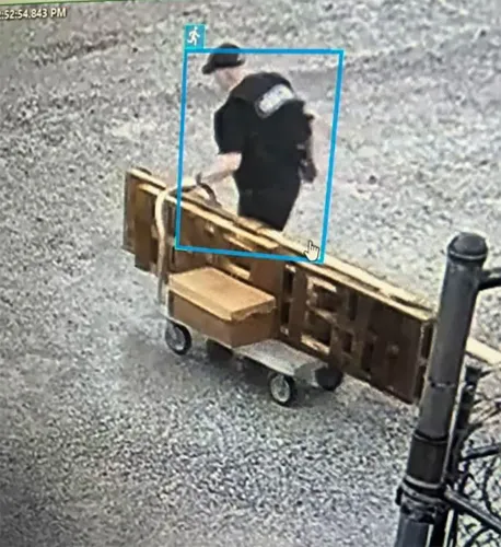 شخص يرتدي زيًا مموهًا باللون الأسود ويجر عربة تحتوي على صناديق، يظهر في لقطات كاميرا مراقبة أثناء هروبه من سجن أركنساس.