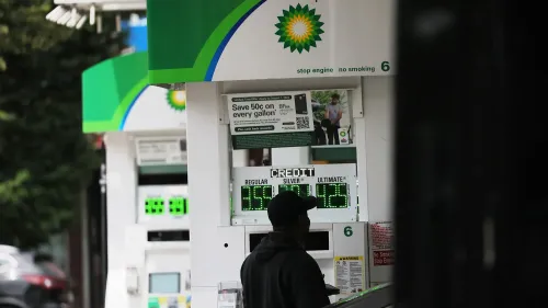 عميل يملأ سيارته بالوقود في محطة BP، حيث تظهر أسعار الوقود على الشاشة، وسط تقارير عن محادثات استحواذ محتملة بين شل وBP.