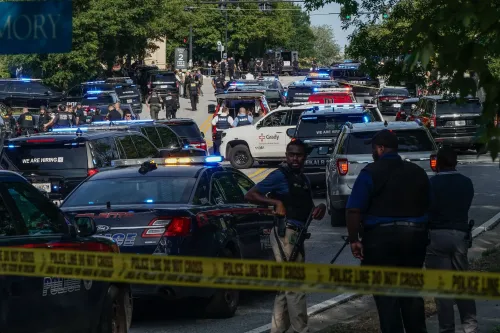 موقع حادث إطلاق نار في أوستن، تكساس، حيث تتواجد سيارات الشرطة والأفراد الأمنيون، مع أضواء الطوارئ.