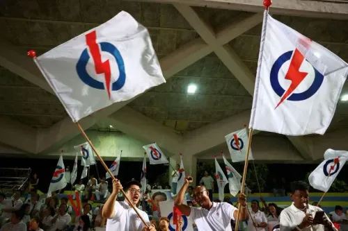 أنصار حزب العمل الشعبي في سنغافورة يحتفلون بفوزهم في الانتخابات، حاملين الأعلام التي تحمل شعار الحزب، وسط أجواء من الحماس.