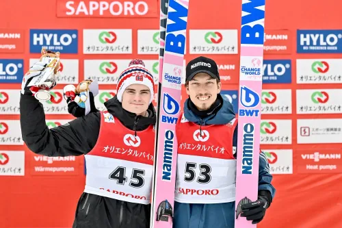لاعبا القفز على الجليد النرويجيان ماريوس ليندفيك ويوهان أندريه فورفانغ يحتفلان بالميداليات في سابورو، وسط مزاعم التلاعب بالمعدات.