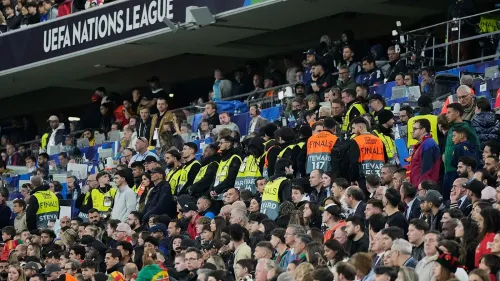 مشجعو كرة القدم في ملعب ميونيخ خلال نهائي دوري الأمم، مع وجود طاقم الأمن في المنطقة بعد حادث سقوط مؤلم.