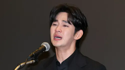 كيم سو هيون يتحدث في مؤتمر صحفي، معبرًا عن مشاعره بعد اتهامات تتعلق بعلاقته بكيم ساي-رون الراحلة، وسط أجواء عاطفية.