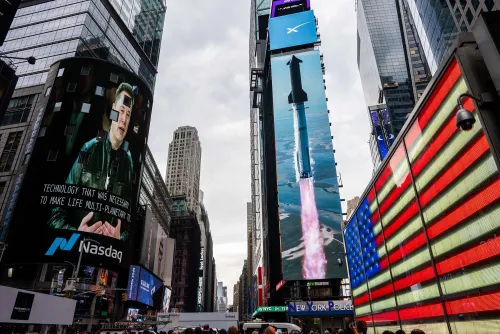 شاشات ضخمة في تايمز سكوير بنيويورك تعرض صوراً لإيلون ماسك وصاروخ لشركة SpaceX مع العلم الأمريكي، تعكس تأثير الشركة في التكنولوجيا والفضاء.