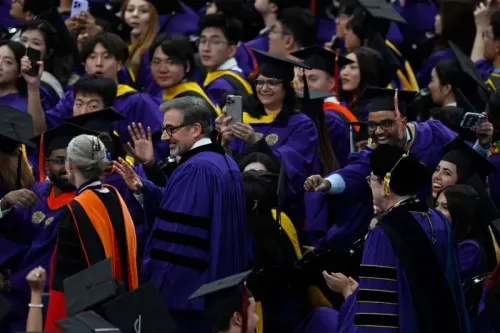 حفل تخرج في جامعة نورث وسترن 2025، حيث يرقص الخريجون في أجواء احتفالية، مع تفاعل الحضور وتوثيق اللحظة عبر الهواتف.