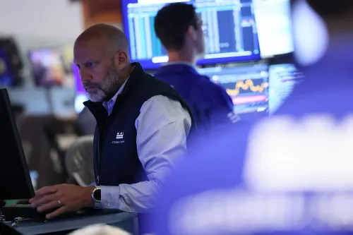 متداول يركز على شاشات الأسهم في بورصة وول ستريت، مع بيانات السوق تظهر خلفه، تعكس حالة عدم اليقين في السوق.