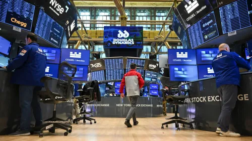 مستثمرون يعملون في بورصة نيويورك، مع شاشات تعرض مؤشرات الأسهم مثل ستاندرد آند بورز 500 وداو جونز، في أجواء تداول نشطة.