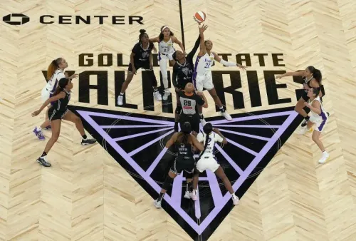 تظهر الصورة لحظة بداية مباراة كرة السلة لفريق غولدن ستيت فالكيريز، حيث تتنافس اللاعبات في دائرة البداية على الكرة.