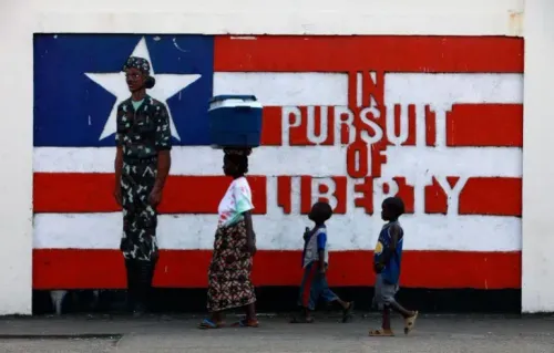 جداريات في ليبيريا تظهر جنديًا وعبارة "في السعي نحو الحرية"، مع امرأة تحمل وعاءً على رأسها وأطفال يسيرون بجانبها، تعكس الثقافة المحلية.