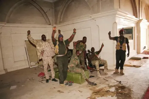 جنود من القوات المسلحة السودانية يحتفلون بعد استعادة السيطرة على الخرطوم، في قاعة داخل القصر الرئاسي.