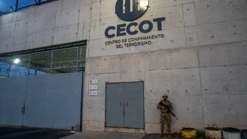 مدخل سجن "سيكوت" في السلفادور، حيث يُحتجز المجرمون. يُظهر الحراسة العسكرية والظروف القاسية المرتبطة بالاحتجاز هناك.
