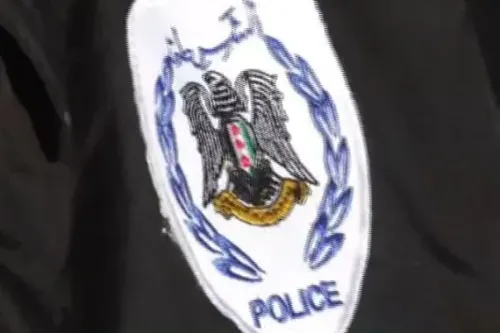 شعار الشرطة السورية يظهر على زي رسمي، يعكس جهود قوات الأمن في مواجهة التهديدات الإرهابية في حلب.