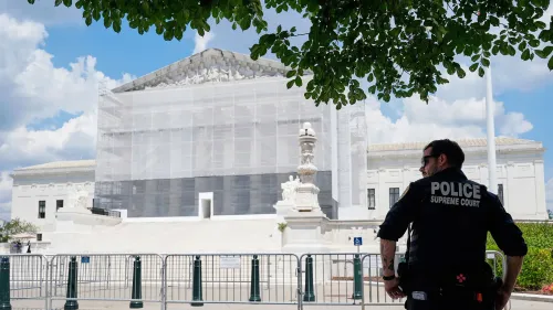 شرطي يقف أمام المحكمة العليا الأمريكية، التي تُغطى بشبكة أثناء أعمال الترميم، في سياق قضية تمويل الحملات الانتخابية.