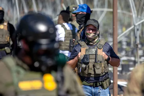 عناصر من إدارة الهجرة والجمارك يرتدون زيًا عسكريًا ويستعدون لعمليات تفتيش في منطقة زراعية بجنوب كاليفورنيا.