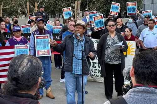 مظاهرة لدعم برنامج الحماية المؤقتة، حيث يتحدث أحد المتظاهرين أمام حشد يحمل لافتات تطالب بالحماية للمهاجرين الفنزويليين.