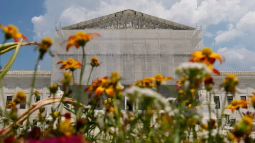 واجهة المحكمة العليا الأمريكية محاطة بالأزهار، مع وجود ستائر على المبنى، مما يعكس التغييرات القانونية الأخيرة.