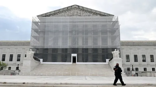 واجهة المحكمة العليا الأمريكية محاطة بسقالات، مع وجود ضابط أمن يسير أمام المدخل، مما يدل على أعمال الصيانة الجارية.