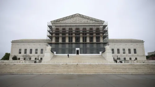 مبنى المحكمة العليا في الولايات المتحدة محاط بسقالات، مع شخص واقف على الدرج الرئيسي، مما يعكس أعمال الترميم الجارية.