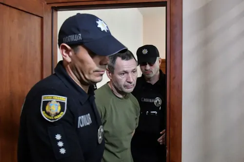 المشتبه به في قتل النائب الأوكراني أندريه باروبي، أثناء نقله من قاعة المحكمة، وسط تواجد رجال الشرطة.