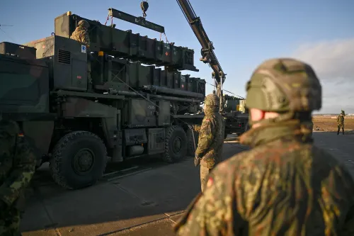 جنود يرتدون خوذات عسكرية يراقبون عملية تحميل نظام دفاع جوي على شاحنة، في سياق تعزيز الدفاعات الأوكرانية ضد الهجمات الروسية.