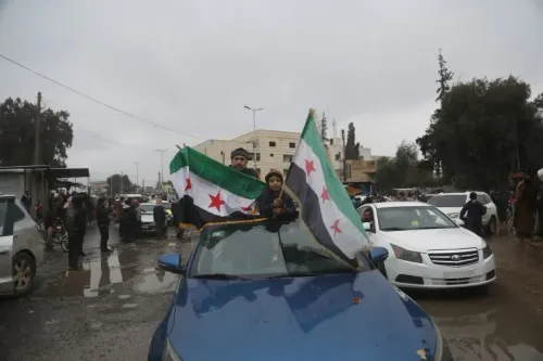 احتفال شعبي في سوريا، حيث يحمل رجل وطفل الأعلام السورية في سيارة، مع وجود حشود في الخلفية، تعبيرًا عن دعم الاتفاق الأخير.