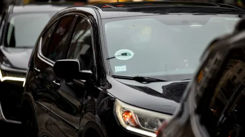 سيارة سوداء تحمل ملصق أوبر، متوقفة في صف من السيارات، تعكس الخدمة الجديدة Route Share التي تستهدف الركاب ذوي الميزانية المحدودة.