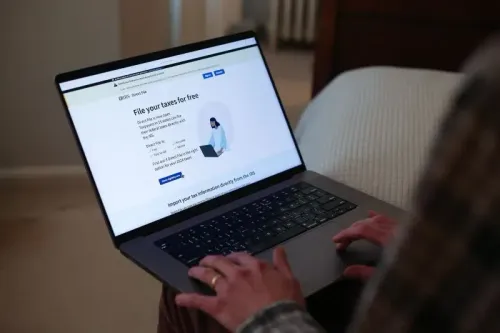 شخص يستخدم حاسوبًا محمولًا لتقديم إقراراته الضريبية عبر الإنترنت، مع واجهة موقع مصلحة الضرائب الأمريكية.