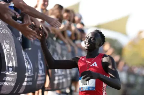 العداء الأسترالي غوت غوت، البالغ من العمر 17 عامًا، يحتفل بعد فوزه بلقب سباق 200 متر في بطولة أستراليا، وسط تشجيع الجماهير.