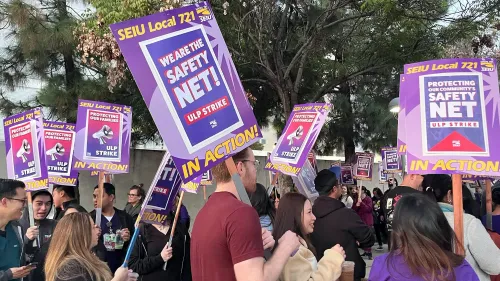 عمال من SEIU Local 721 يحتجون في لوس أنجلوس، حاملين لافتات تطالب بحقوقهم خلال إضراب عن العمل.