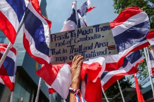 لافتة تحمل عبارة "Prasat Ta Muen Thom ليست من كمبوديا" وسط أعلام تايلاندية، تعكس التوترات الحدودية بين تايلاند وكمبوديا.