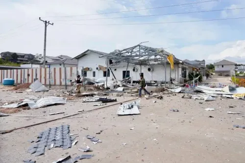 تظهر الصورة دمارًا واسعًا في منطقة سكنية، مع وجود شخصين يتجولان بين الحطام بعد القصف الذي تعرضت له المنطقة الحدودية بين تايلاند وكمبوديا.