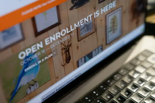 واجهة موقع إلكتروني تعرض معلومات عن فترة التسجيل المفتوحة لتأمين الرعاية الصحية، مع صور توضيحية على الجدار خلف الشاشة.